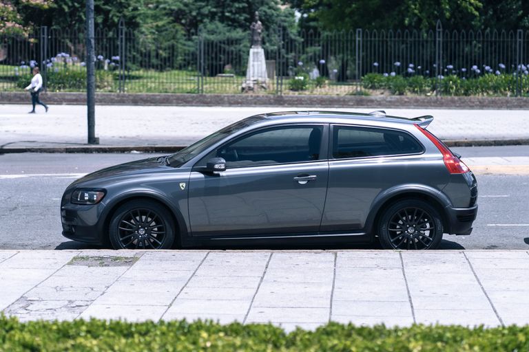Captivating image of a grey compact car parked alongside a city street, perfect for urban lifestyle themes.