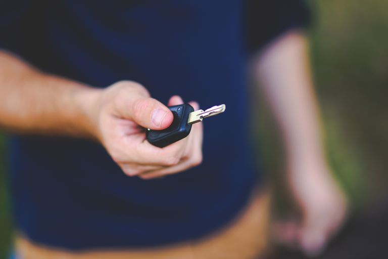 How to Remote Start Your Volvo XC60 With the Key? A hand holding a car key outdoors, emphasizing security and control.