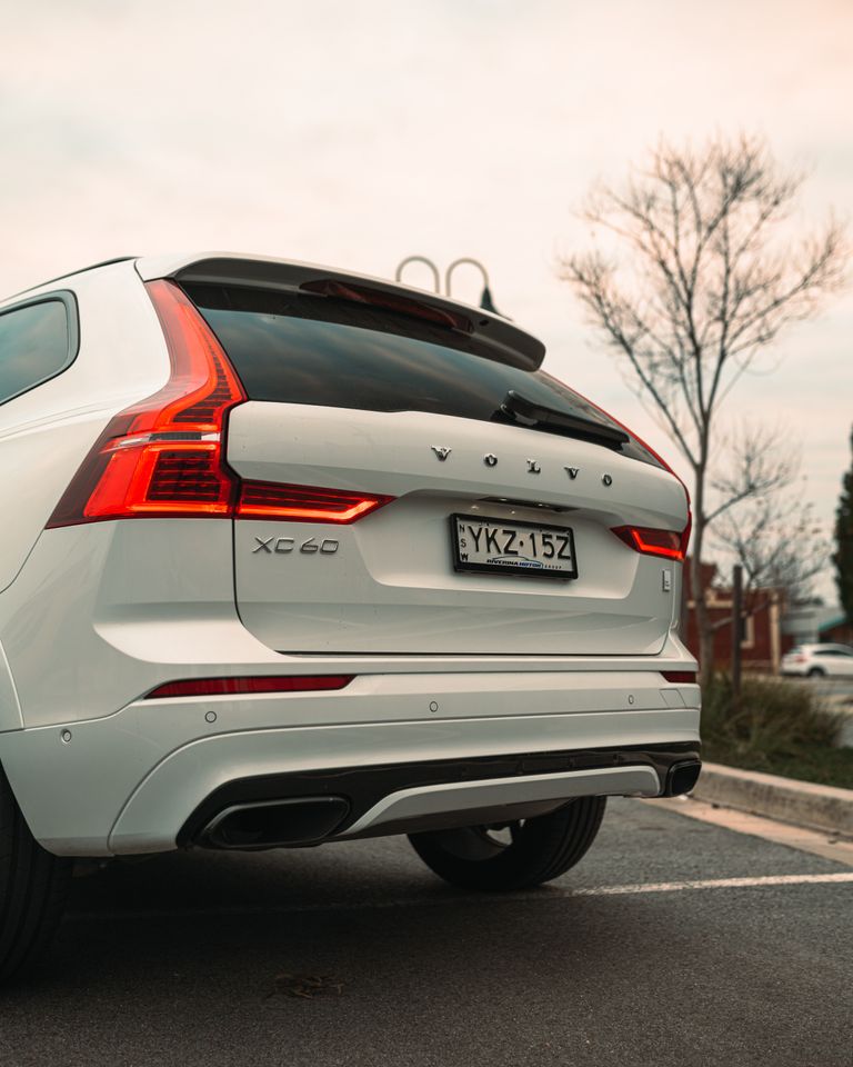 How Much Is a Volvo XC60? A sleek white Volvo XC60 SUV with a visible license plate parked outdoors, showcasing its modern design.