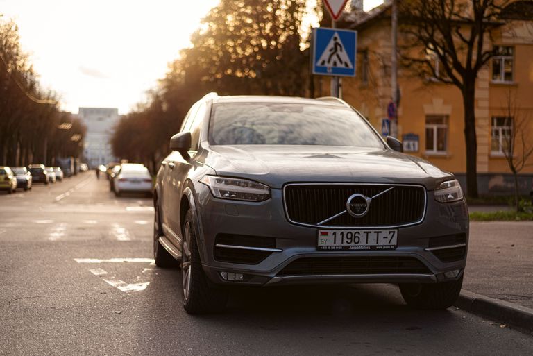 How Long Does a Volvo XC60 Last? A Volvo XC90 parked on an urban street in Minsk during sunset with urban surroundings.