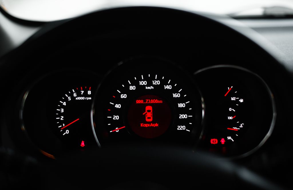 How to Check Total Mileage on a 2024 Volvo XC60? Car dashboard showing a warning light with various dials and gauges in focus.